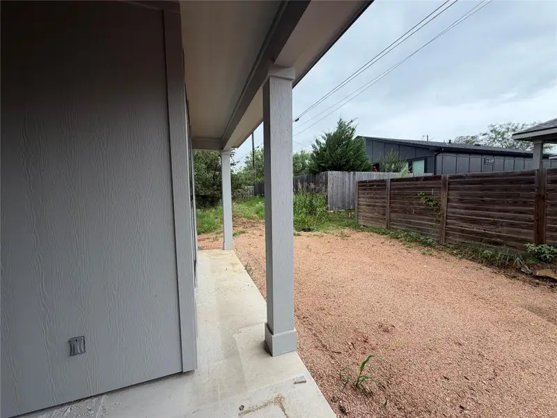 A gravel yard bordered by fencing offers practical outdoor space.