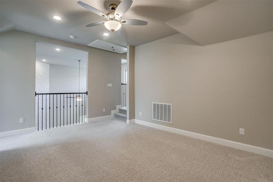 Carpeted spare room with ceiling fan