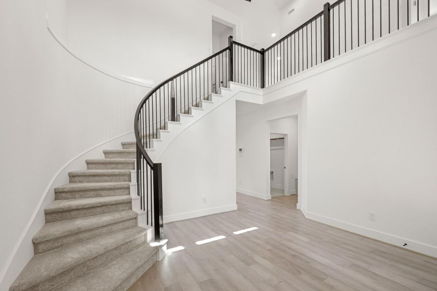 Grand Entry With Stunning Curved Staircase And Soaring Ceilings