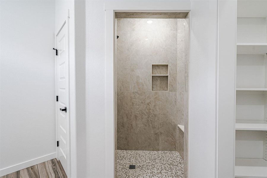 Tiled shower with mosaic floor and built-in shelving offers a refreshing bathing experience. Tiled shower with mosaic floor and built-in shelving offers a refreshing bathing experience.
