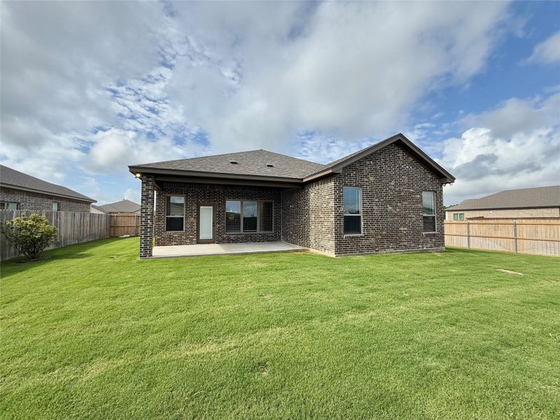 Expansive grassy lawn with a covered patio
