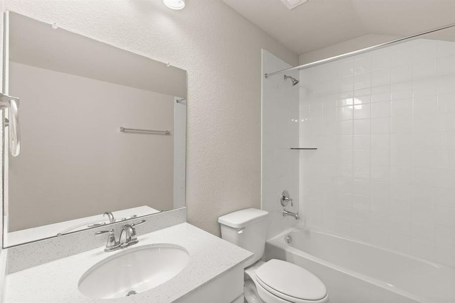 The secondary bath features tile flooring, white cabinetry and light countertops and a shower/tub combo. Perfect for accommodating any visiting family and friends.