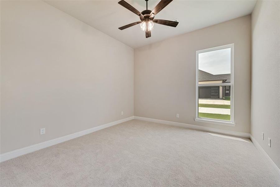 Empty room with light carpet and ceiling fan
