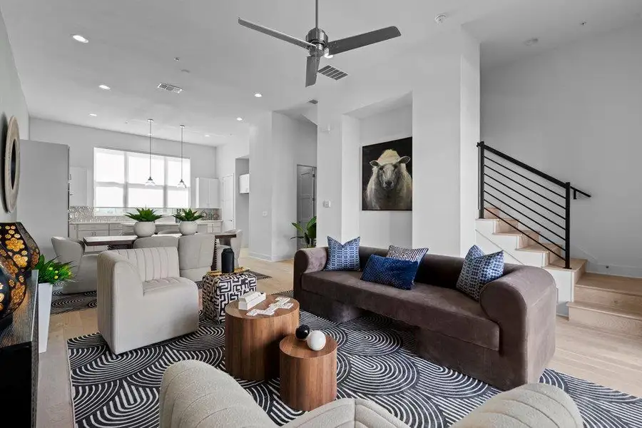An open floorplan connects the living spaces with hardwood flooring and a stylish staircase. An open floorplan connects the living spaces with hardwood flooring and a stylish staircase.