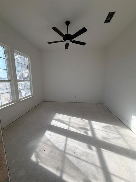Spare room with a ceiling fan and concrete flooring