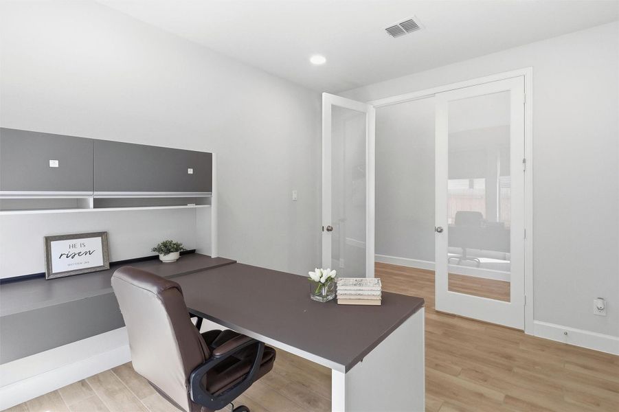 A second view highlights the office's spacious design and versatility. Glass French doors provide privacy while maintaining an open, connected feel, making this an ideal space for a home office, library, hobby room, or quiet retreat.