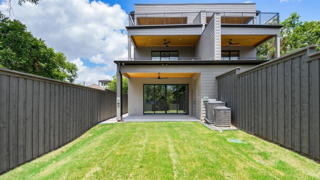 Back of property with a yard, ceiling fan, a patio, central AC, and a balcony