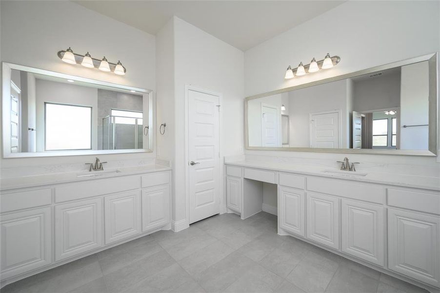 Bathroom with vanity, a shower with shower door, and plenty of natural light