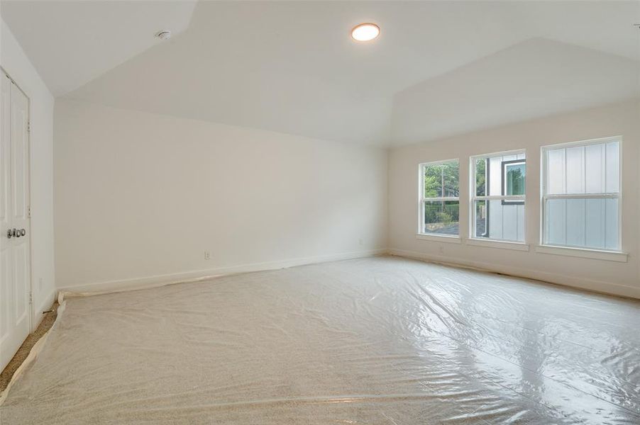 Unfurnished room featuring vaulted ceiling