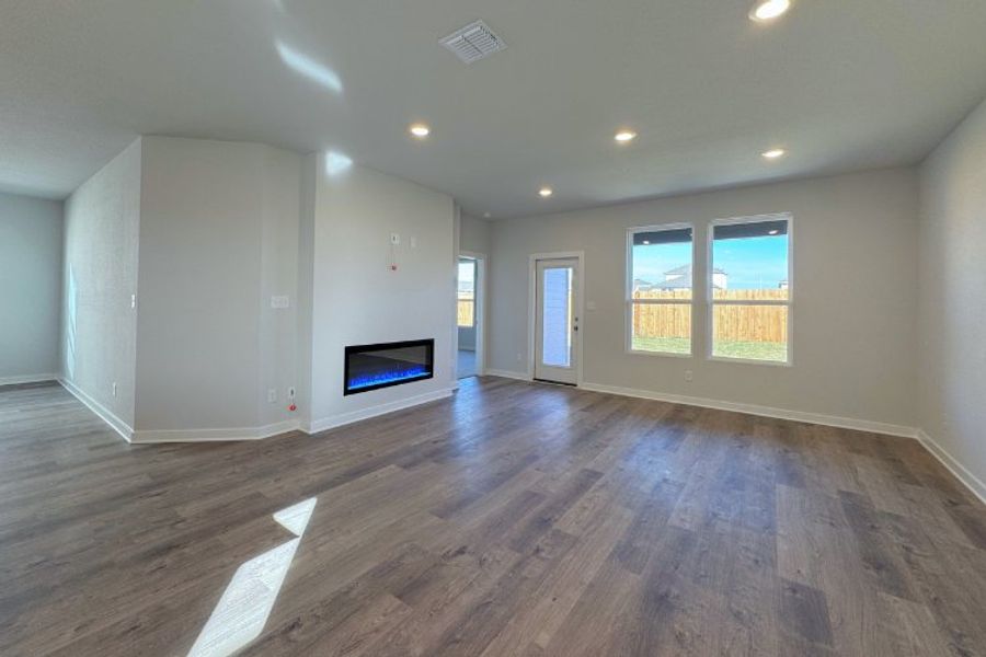 A room with a wood floor and a wood floor with a television.