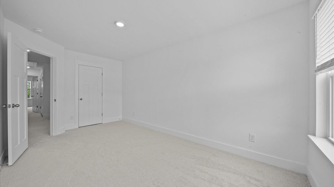 Carpeted bedroom with walk-in closet in two story townhome at Ransdell Pointe by DRB Homes in Spartanburg, SC