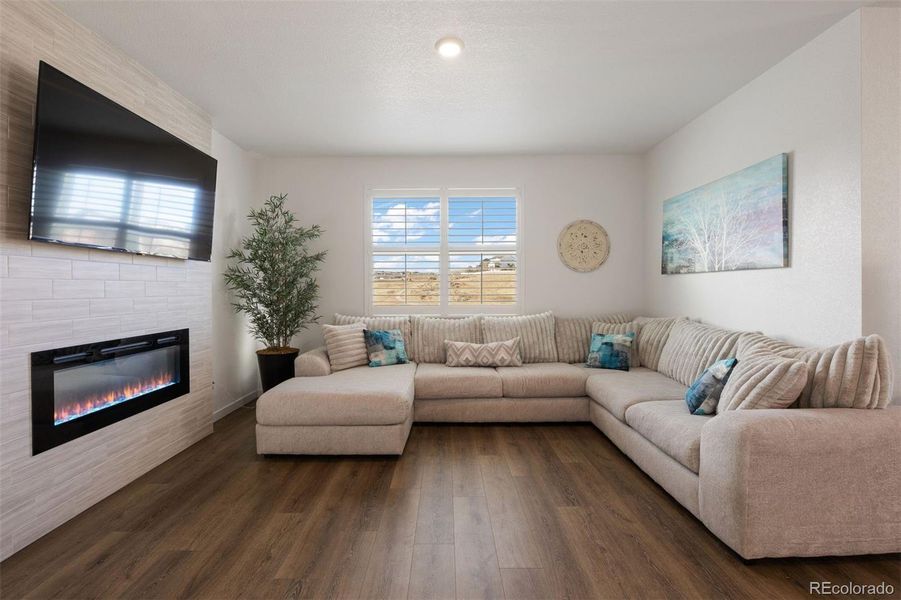 Cozy living room with a SimpliFire gas fireplace framed by floor-to-ceiling tile.