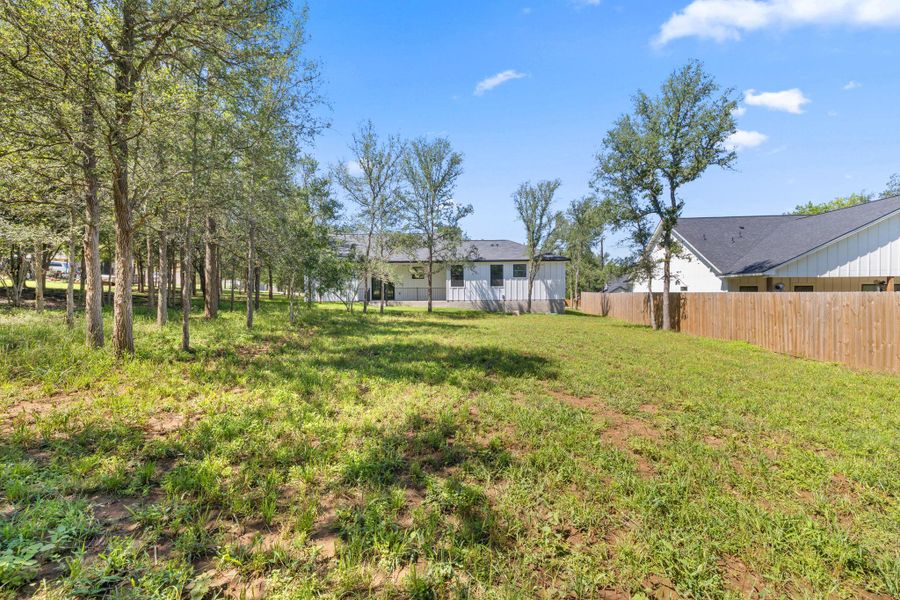 A spacious yard with natural greenery and mature trees offers private outdoor living. A spacious yard with natural greenery and mature trees offers private outdoor living.