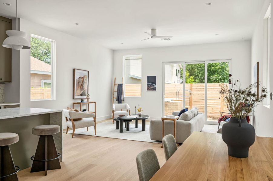An open-concept layout showcases light-toned hardwood flooring and recessed lighting.