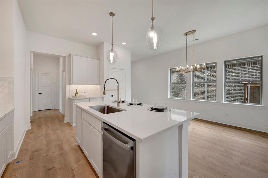 Modern kitchen island with an undermount stainless steel sink and gooseneck faucet