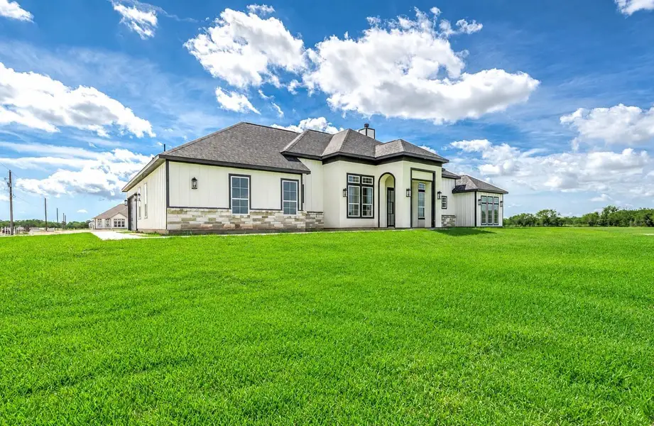 Another angle of the front exterior, showcasing the home’s modern design and open surroundings. Another angle of the front exterior, showcasing the home’s modern design and open surroundings.