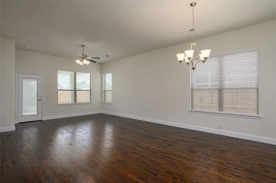 family room featuring ceiling fan with notable chandelier and dark hand scraped hardwood floors