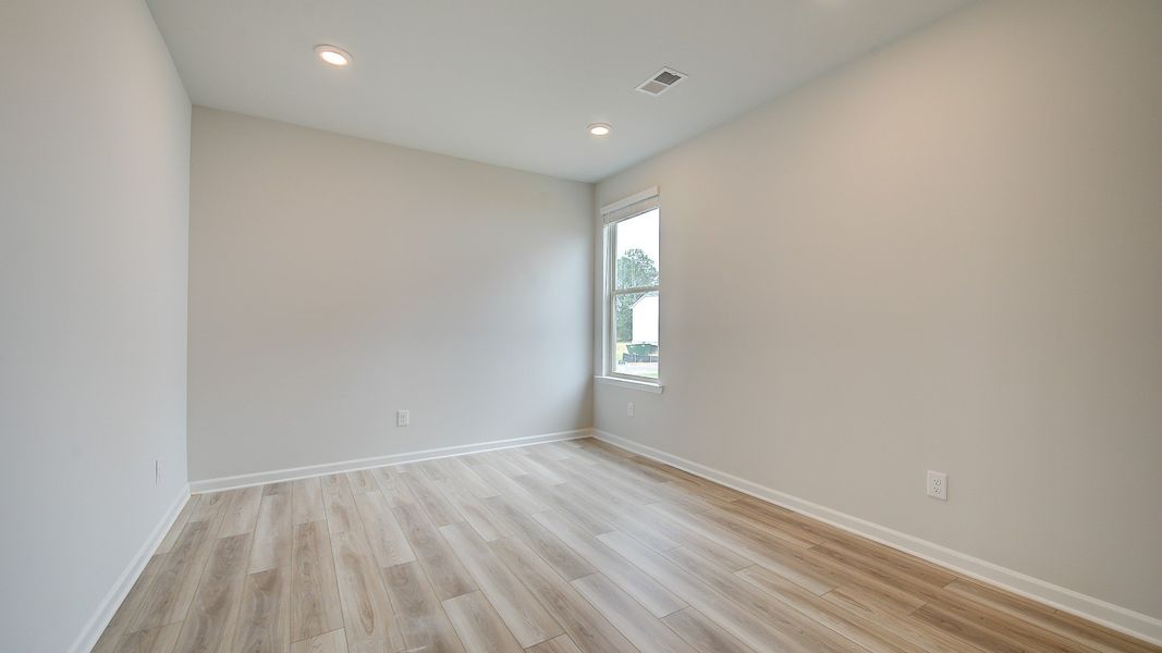 Meridian II first-floor study with carpet flooring and natural light at Brighton in Locust Grove, GA.