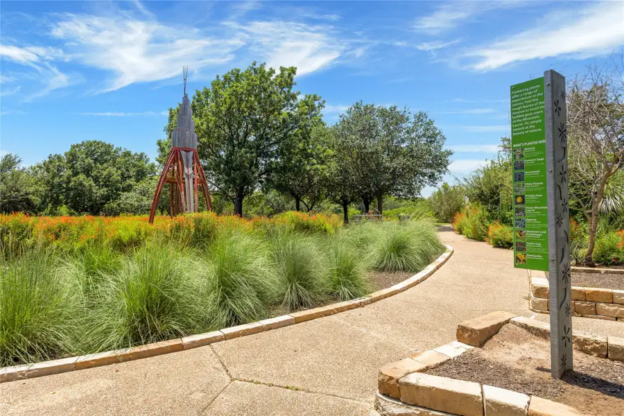 Meandering pathways invite exploration through verdant gardens with a captivating natural sculpture.