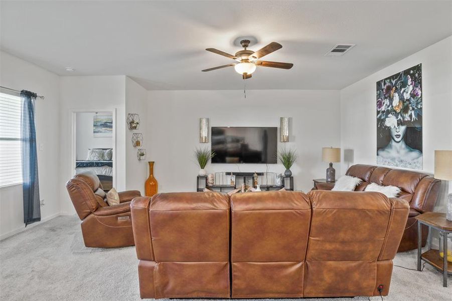 Living area with light carpet and a ceiling fan