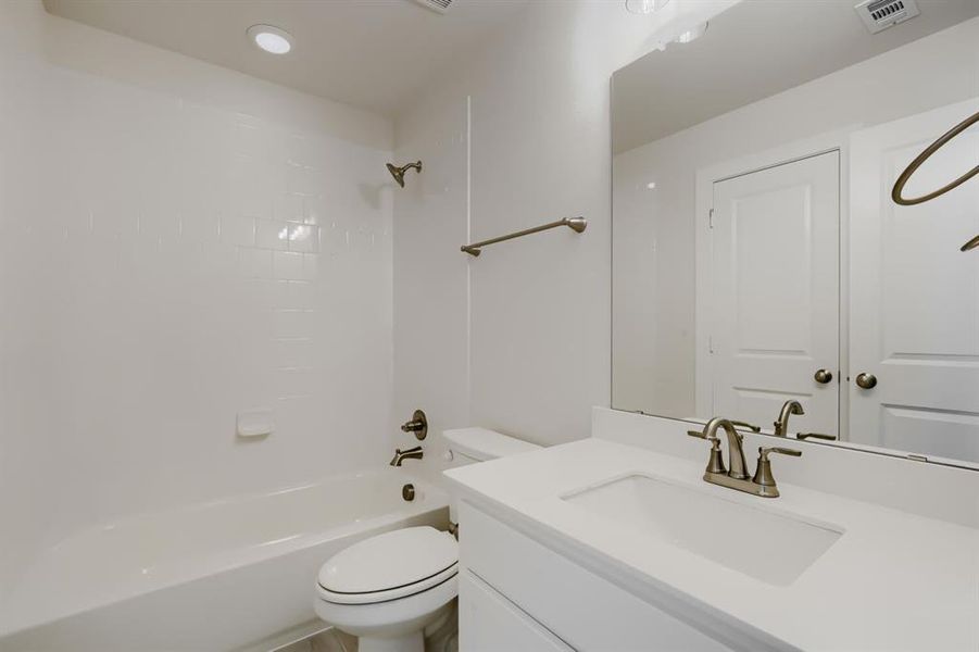 Bathroom featuring a vanity with an integrated sink, brushed nickel faucet, and a large mirror