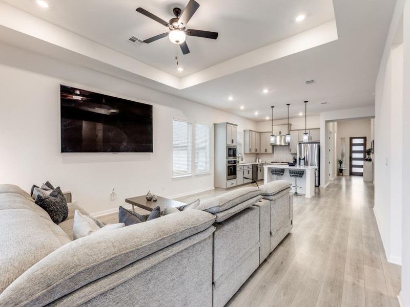 Wide sightlines from the living room to the kitchen highlight the home’s ight-filled spaces, and clean, modern finishes throughout.