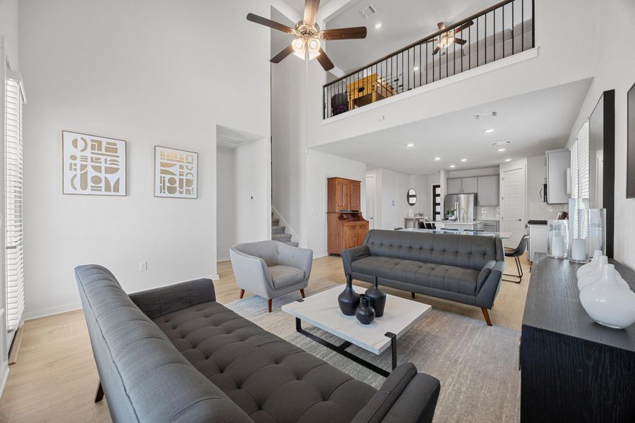 Living area with recessed lighting, a high ceiling, a ceiling fan, and open to the upstairs game room.