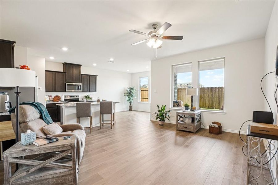 Living room with light wood-style floors, a ceiling fan, and recessed lighting Living room with light wood-style floors, a ceiling fan, and recessed lighting