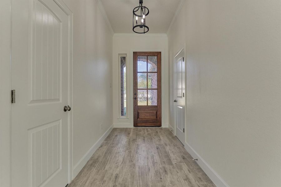 Foyer/entryway with half bath to the right and coat closet to the left. Foyer/entryway with half bath to the right and coat closet to the left.