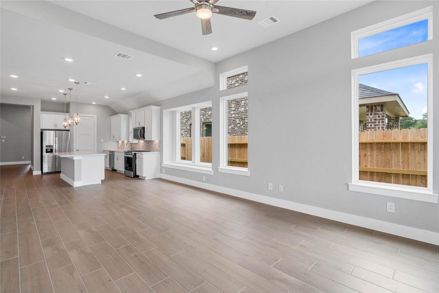 This expansive view from the back of the house showcases a seamless, open-concept layout that creates a warm and inviting path.