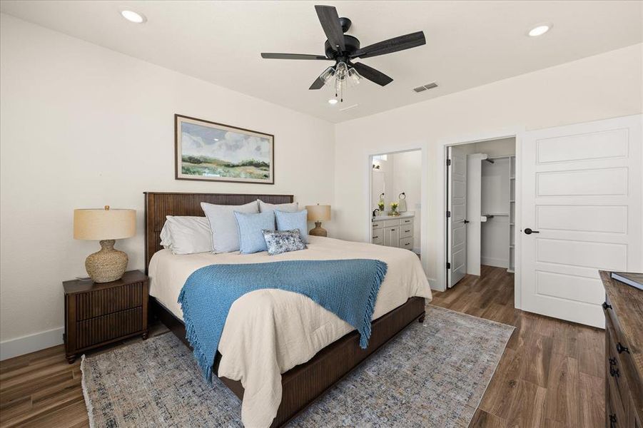 Spacious room featuring wood-finish flooring, recessed lighting, and a ceiling fan with light fixture