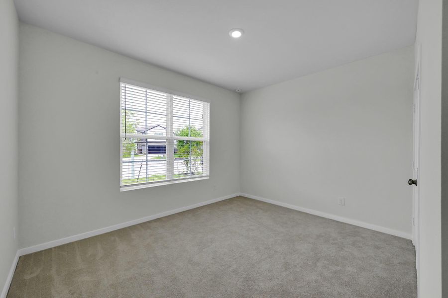 Secondary bedroom located at the front of the home with natural light and upgraded carpeting, ideal for guest or home office Secondary bedroom located at the front of the home with natural light and upgraded carpeting, ideal for guest or home office