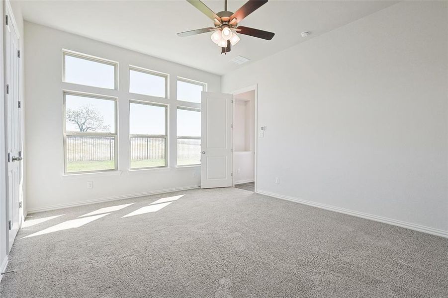 Carpeted spare room with ceiling fan