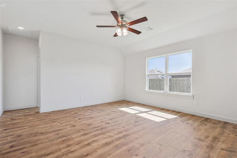 Unfurnished room featuring lofted ceiling, ceiling fan, and light hardwood / wood-style floors