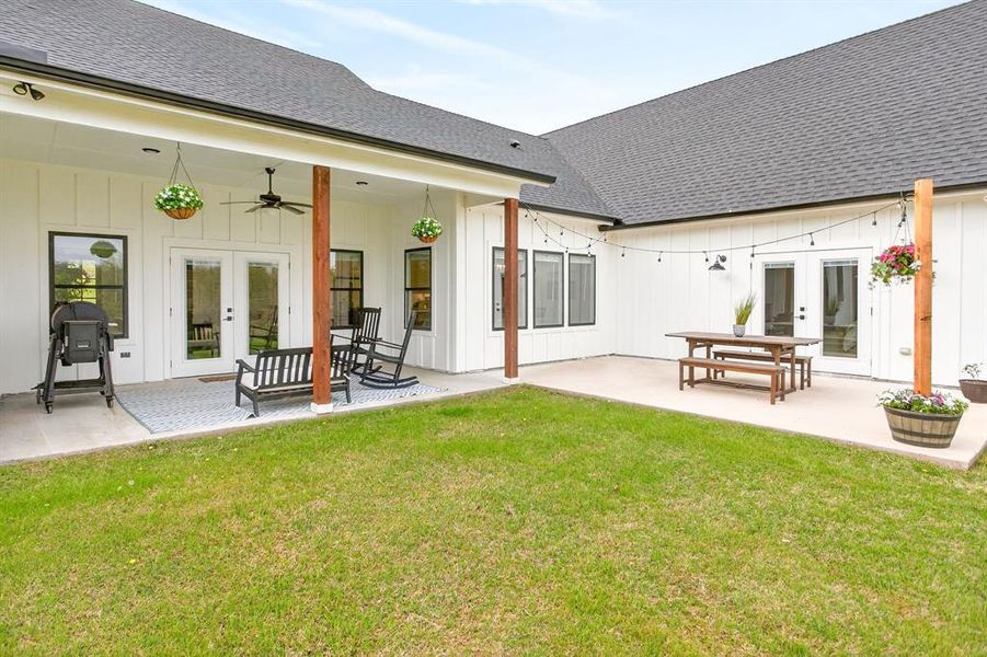 Back of property featuring french doors, roof with shingles, a patio area, and a ceiling fan Back of property featuring french doors, roof with shingles, a patio area, and a ceiling fan