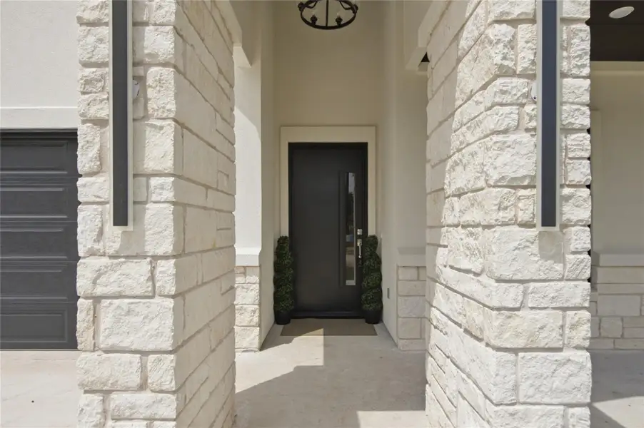 A welcoming entry framed by robust stone columns beckons visitors into this inviting residence. A welcoming entry framed by robust stone columns beckons visitors into this inviting residence.