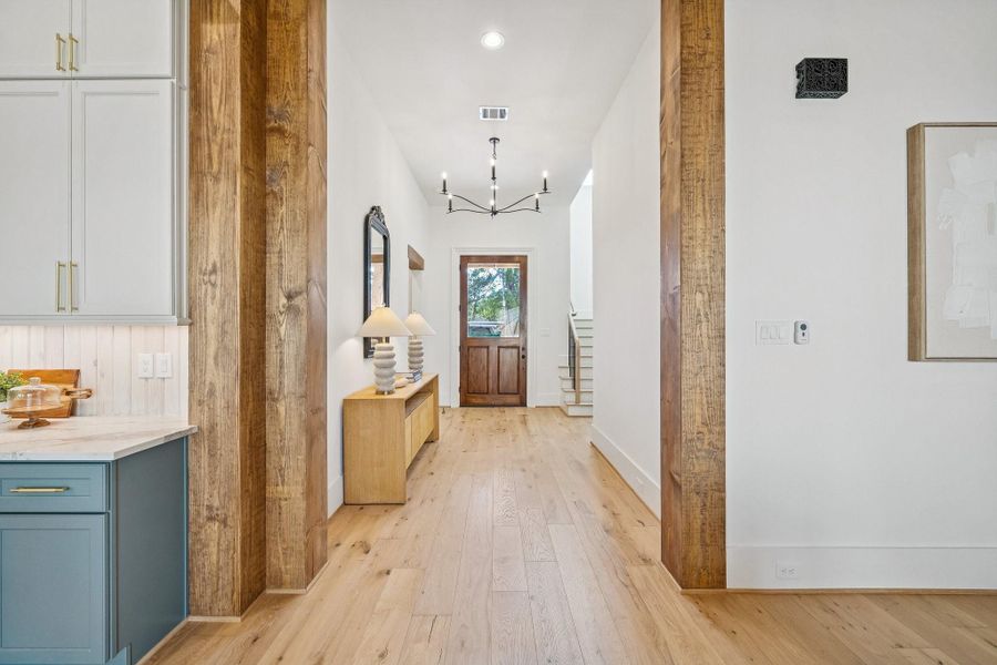 From the living room with wood framed cased opening looking back at the impressive front door. From the living room with wood framed cased opening looking back at the impressive front door.