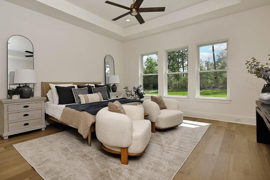 Primary bedroom is spacious with elevated feel in recessed ceiling detail, window wall with beautiful outdoor views, and french oak wood floors. Expansive walk-in closet another great feature.