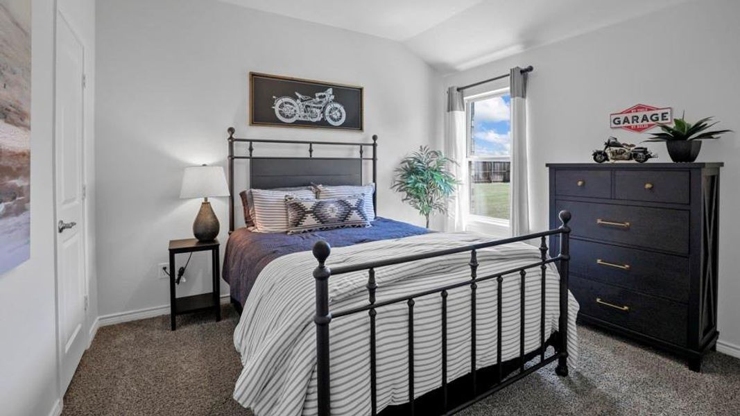 Bedroom featuring dark colored carpet and vaulted ceiling