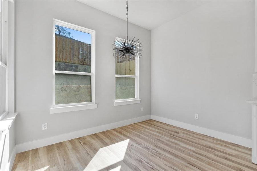 Unfurnished dining area with a chandelier and light wood-type flooring