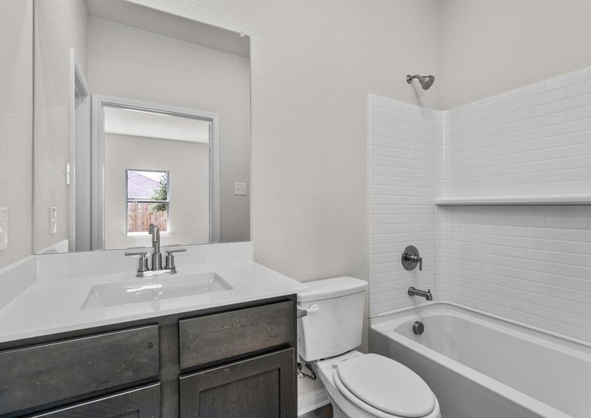 The master bathroom has a vanity and shower-tub combo.