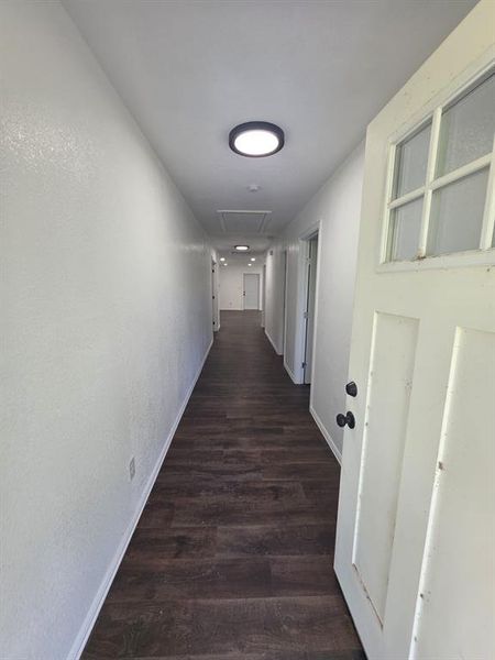 Corridor featuring wood finished floors and attic access Corridor featuring wood finished floors and attic access