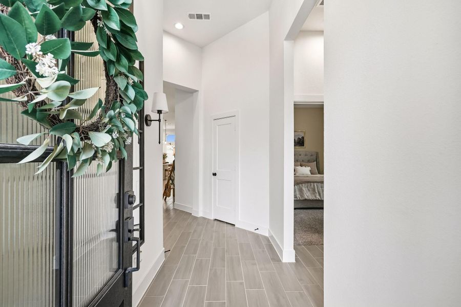 A beautifully landscaped walkway leads to the impressive 8-foot front entry door, setting the tone for the home’s refined architectural character.