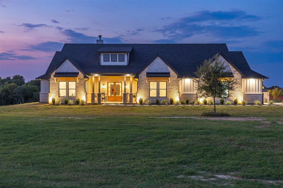 View of front of property with a porch, a lawn, a chimney, french doors, and a shingled roof