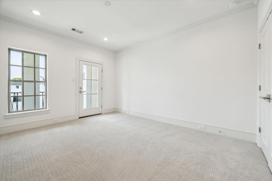 Third-floor Secondary Bedroom with walk-in closet, and glass door for access to balcony.