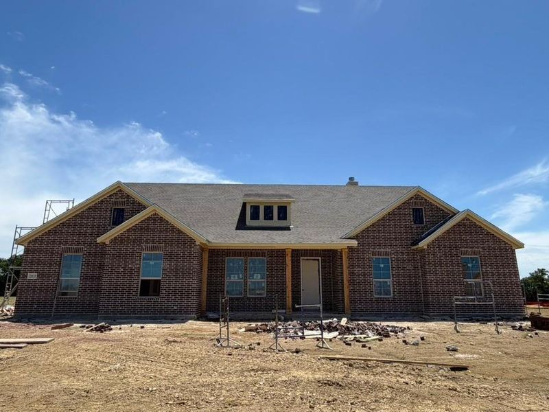 Brick exterior featuring gabled rooflines, a central dormer, a covered entry, and wood-finish support columns Brick exterior featuring gabled rooflines, a central dormer, a covered entry, and wood-finish support columns
