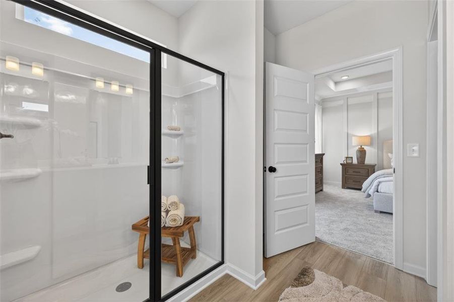 Shower with a black-framed glass enclosure, integrated shelving, and overhead lighting
