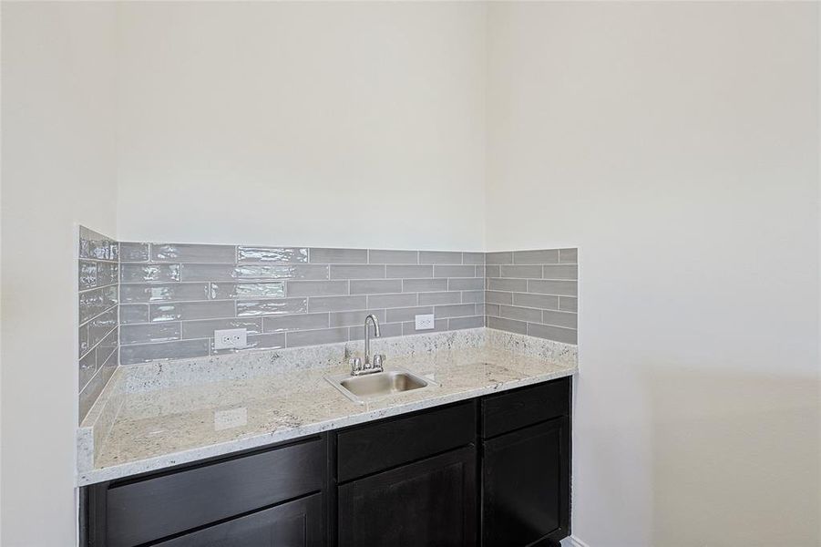 Bathroom featuring decorative backsplash and sink