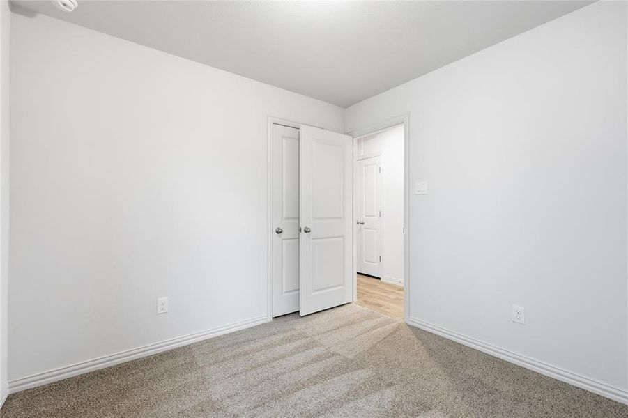 Spare room with carpet and baseboards