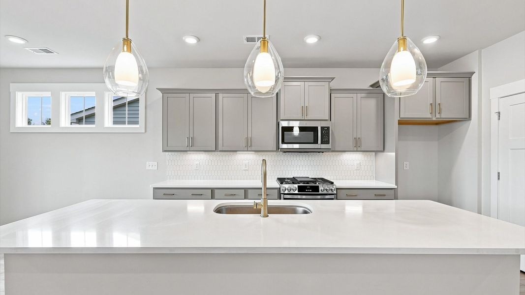 Top-notch kitchen featuring pendant lighting over a statement 10-foot island with seating Top-notch kitchen featuring pendant lighting over a statement 10-foot island with seating